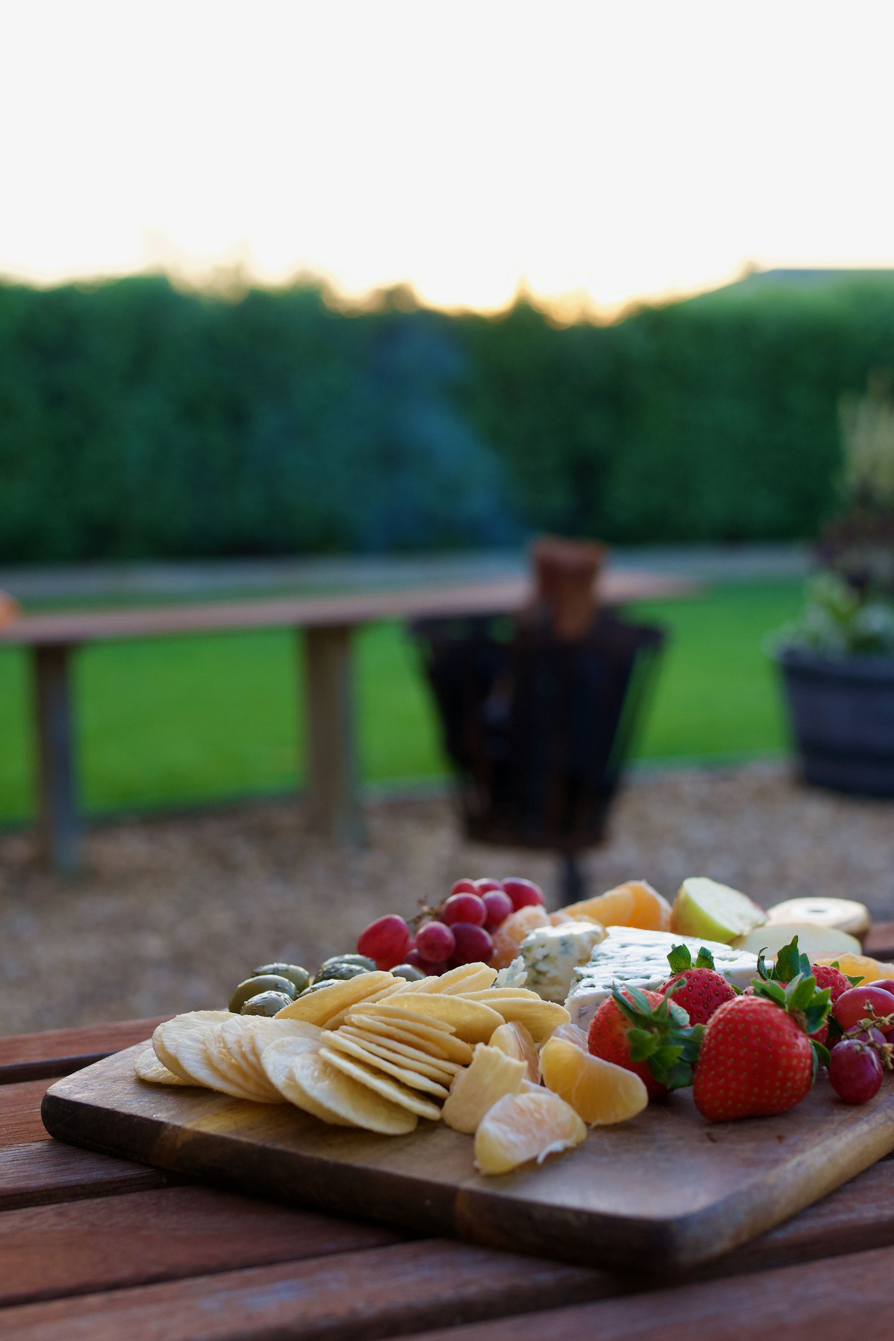 Cheese board laid out on the outdoor table at dusk